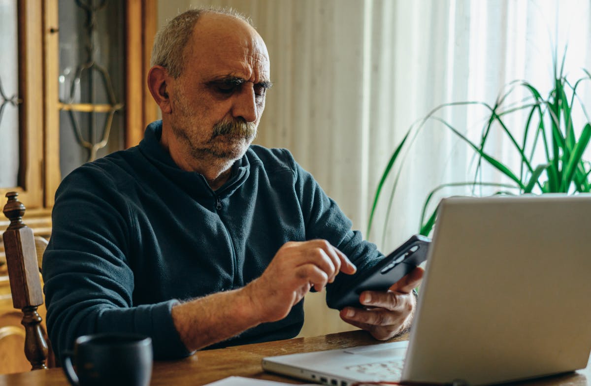 Una persona mayor mirando su celular con desconfianza