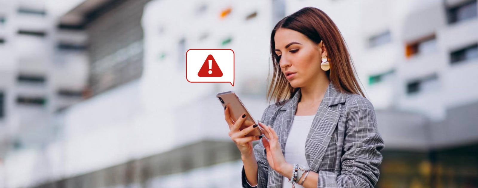 Woman holding a phone with a image box that tells us she just received a spam