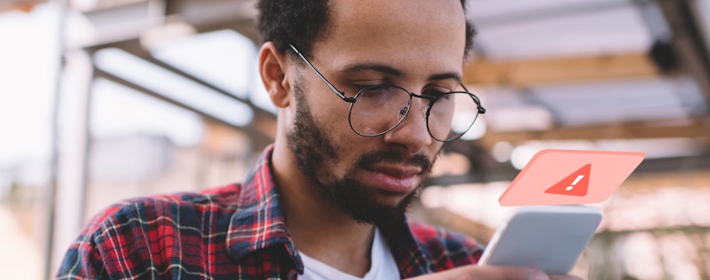 Image of a person looking at his phone and getting a scam