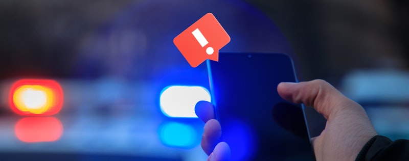 Pic with a phone and police lights in the backgorund